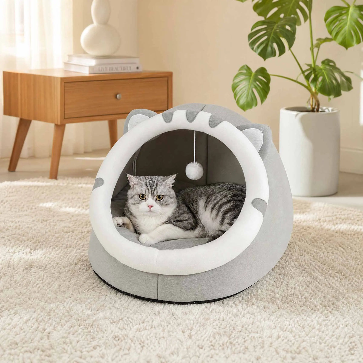 Gray covered cat bed cave tent with cat inside, white ring opening and pom-pom