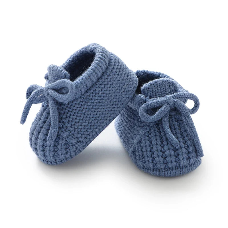 Light blue knitted baby booties with soft lining and tie lace bows