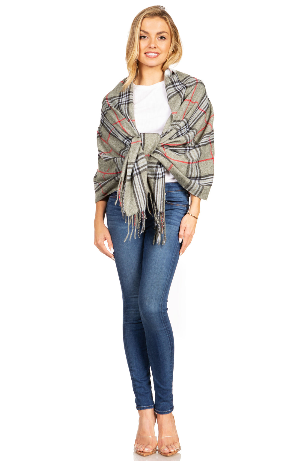 Plaid pashmina shawl in gray with red lines and tassel fringe, worn over white top
