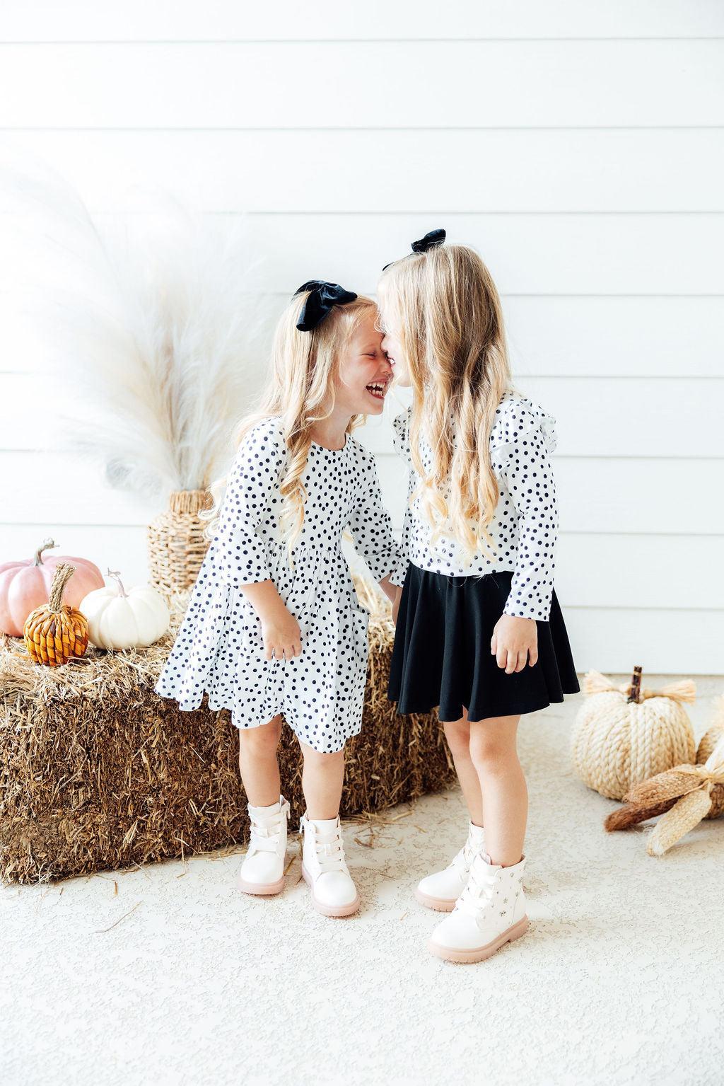 White polka-dot 3/4 sleeve dress with twirly skirt, worn with dark undershorts