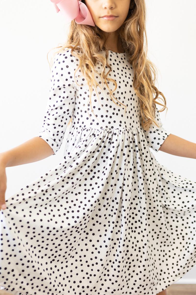 Close-up of white polka-dot twirl dress with gathered bodice and skirt