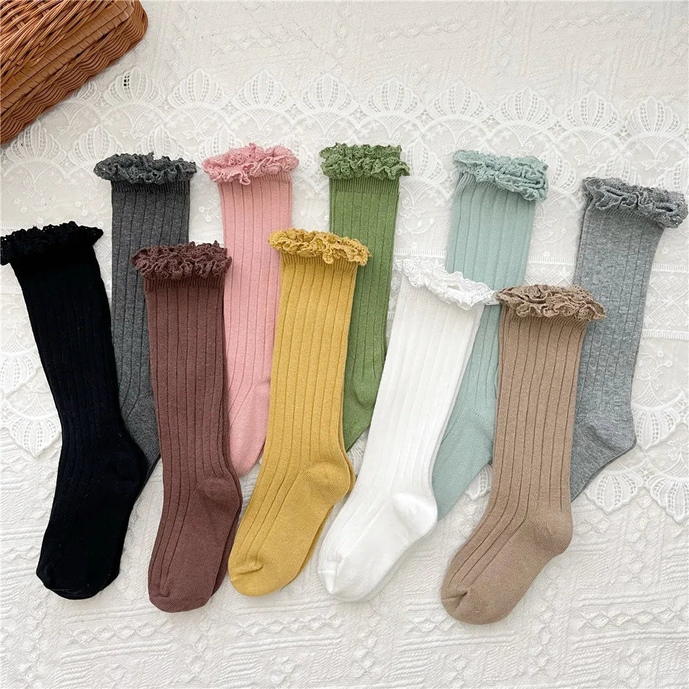 Assorted knee-high ruffle socks with lace cuffs in mixed colors, pairs laid flat