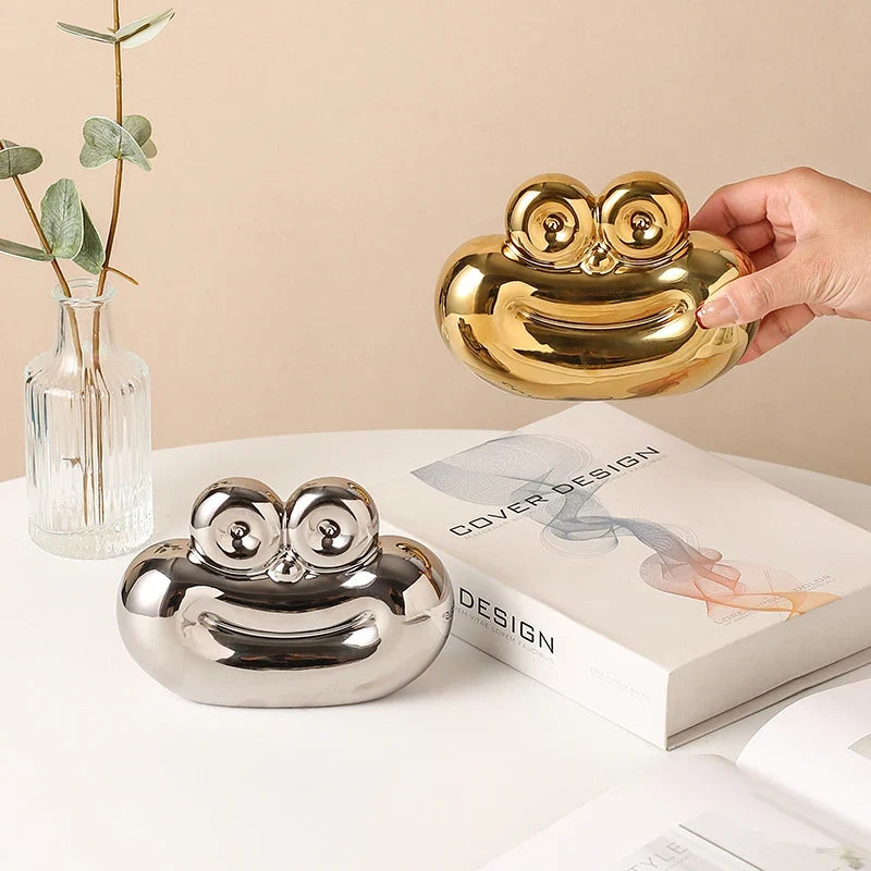 Gold sausage-shaped ceramic ornament held over a silver sausage-shaped ornament