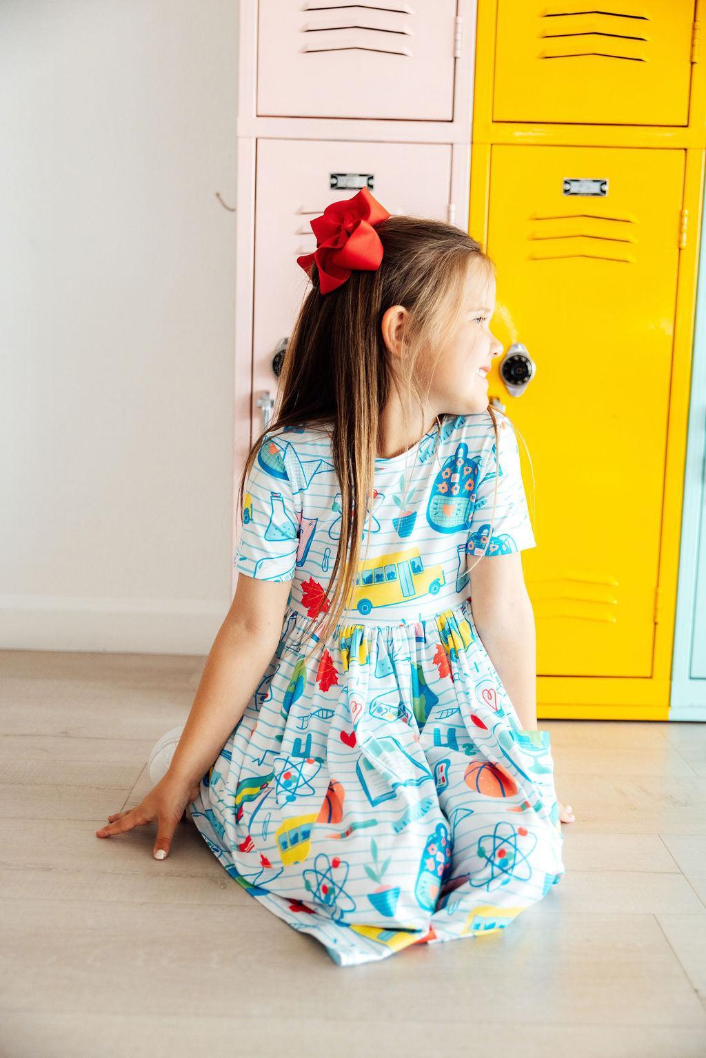 Girls' back view of short-sleeve twirl dress in light blue science-themed print