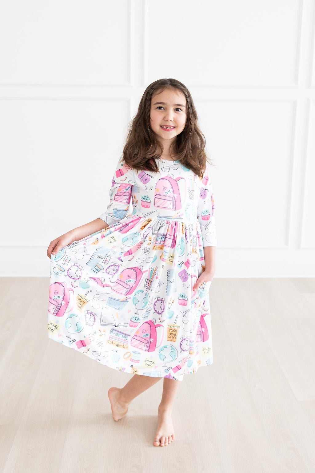 Girls' white 3/4-sleeve twirl dress with colorful school-themed print and flared skirt