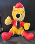 Plush Winnie-the-Pooh bear in red racing outfit, seated with black tie