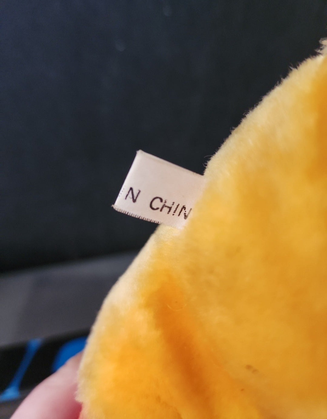 White fabric tag on plush Winnie-the-Pooh bear