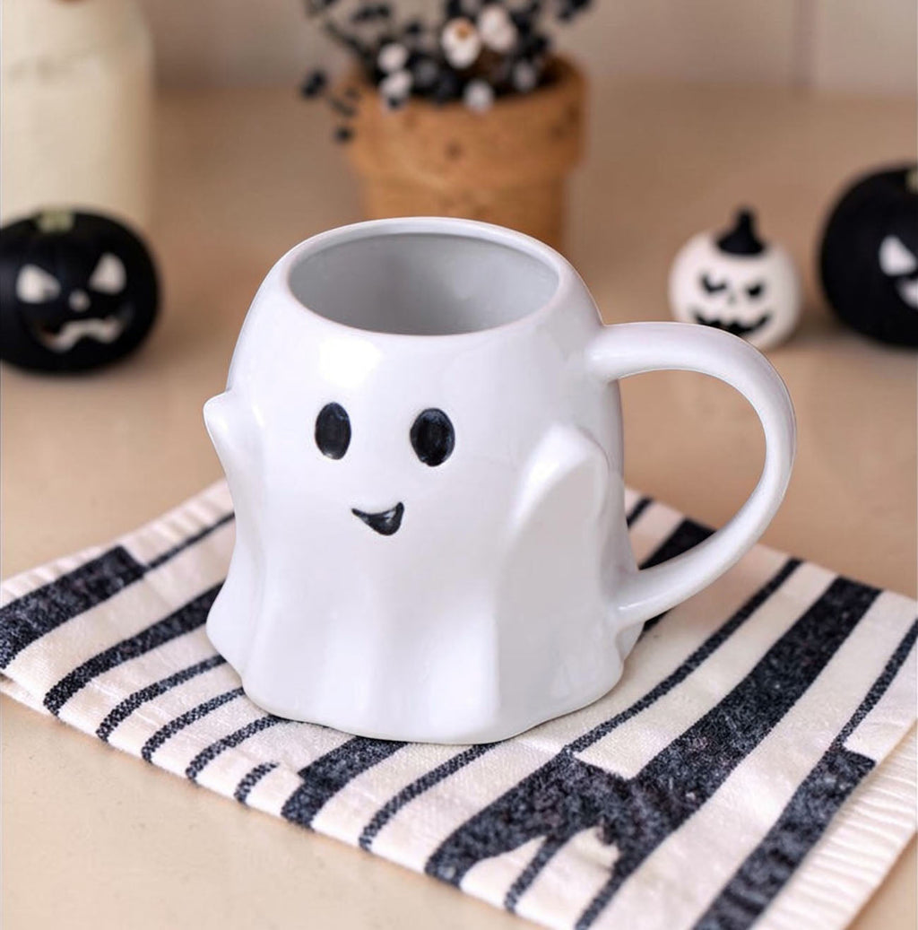 White ghost-shaped ceramic mug with cute face and curved handle