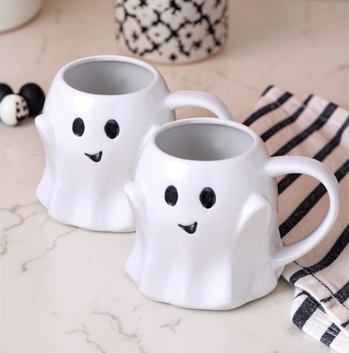 White ghost-shaped ceramic mug pair with cute face and curved handle