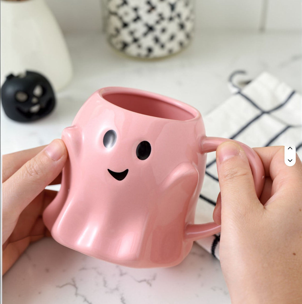 Pink ghost-shaped ceramic mug with rounded ears, smile face, and side handle