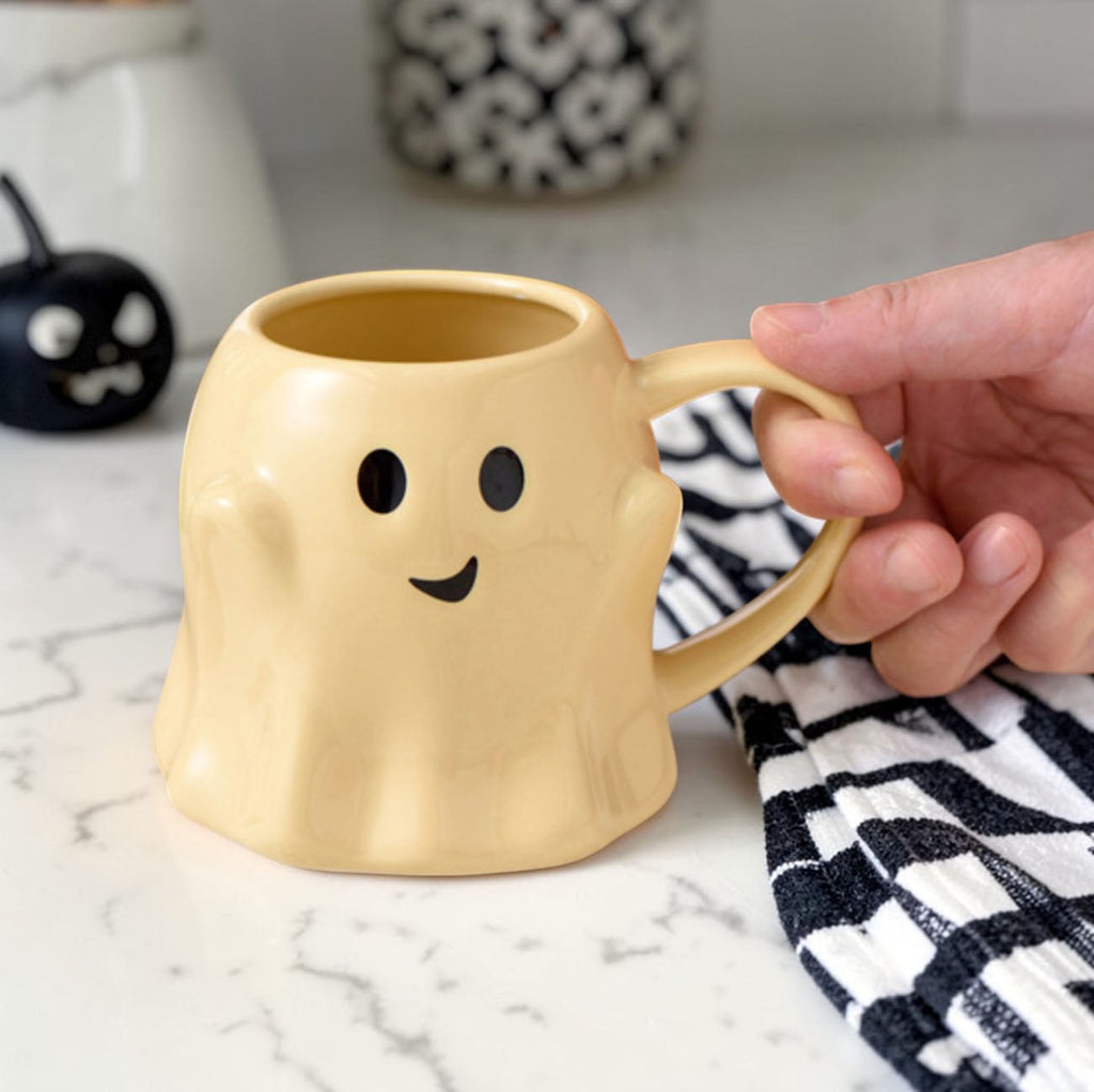Yellow ghost-shaped ceramic mug with cute face and curved handle