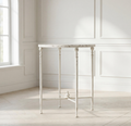 Antiqued metal round side table in antique white with turned legs and open apron