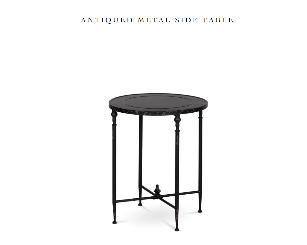 Antiqued metal round side table in weathered black with round top and lower crossbar