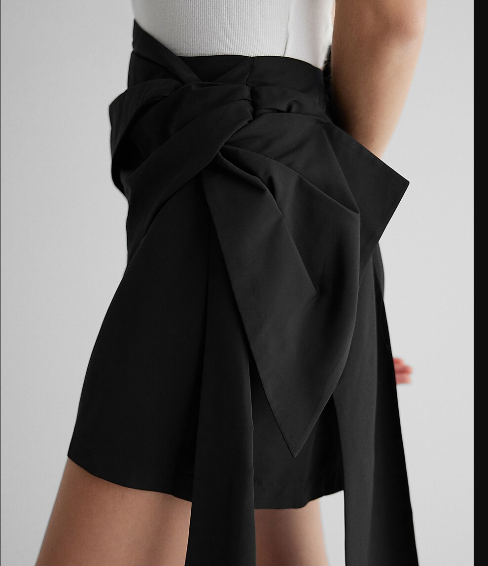 Black high-waisted bow mini skirt with knotted bow at waist, side detail