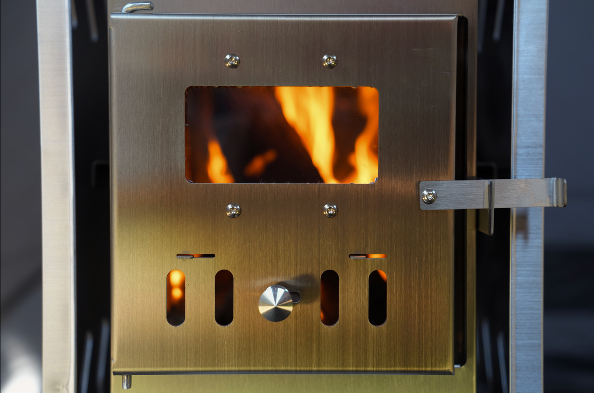 Mini tent sauna stove with open door showing wood fire inside