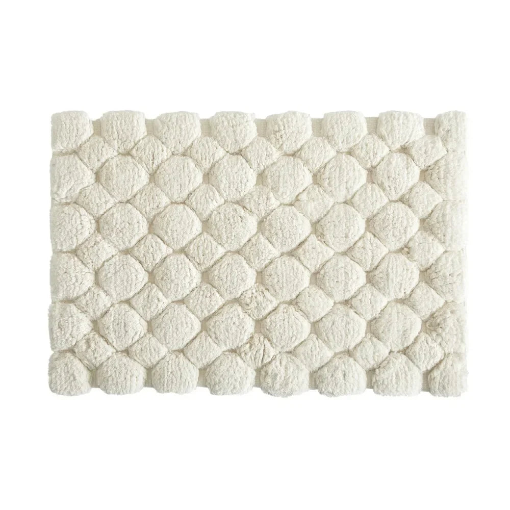 Ivory cotton bath rug mat with raised pebble-like texture, rectangular