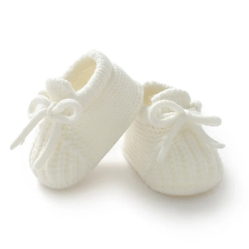Cream knitted newborn booties with bow ties, soft cuff