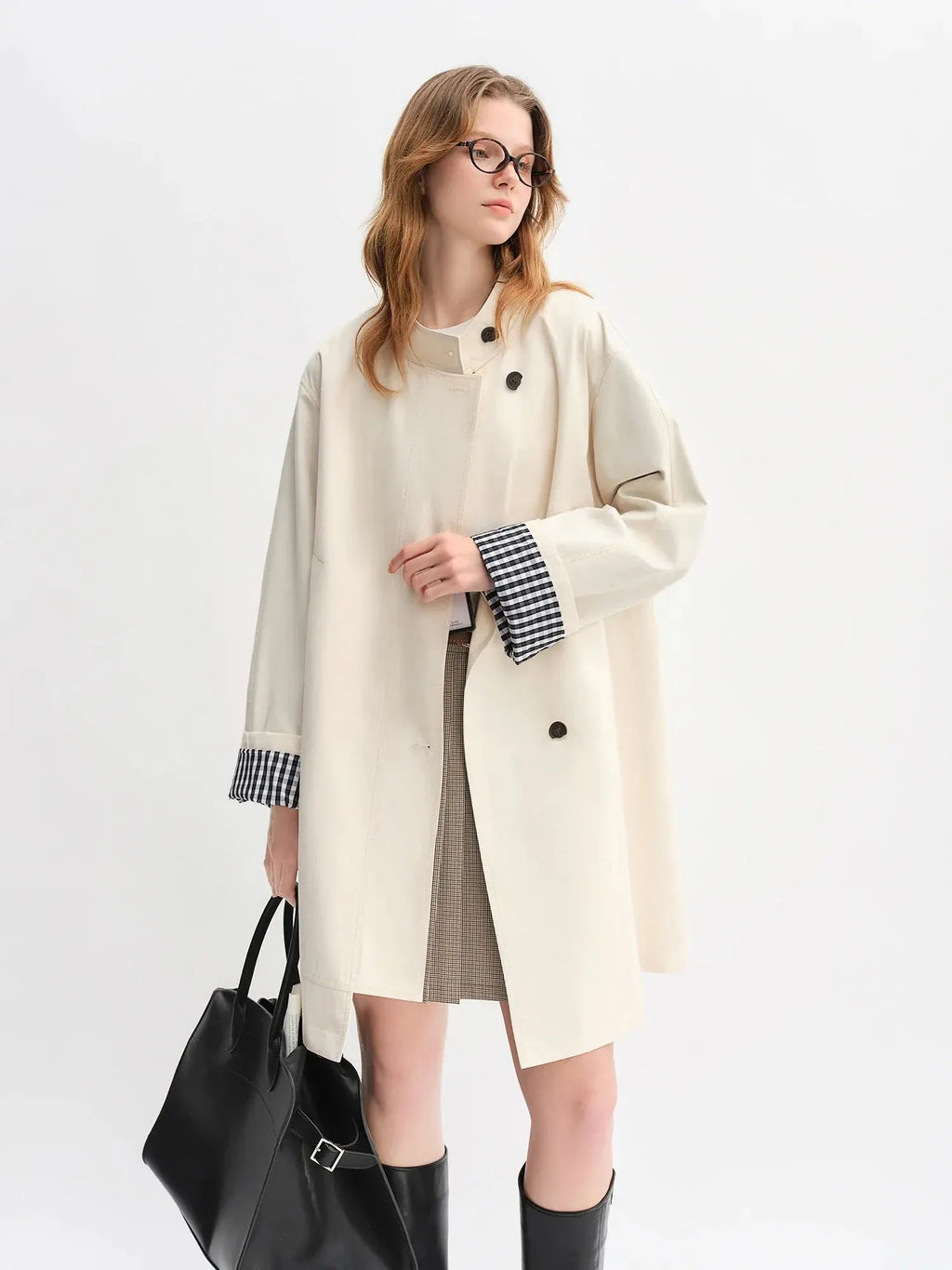 Beige stand-collar windbreaker with black-and-white plaid cuffs, snap buttons, pockets
