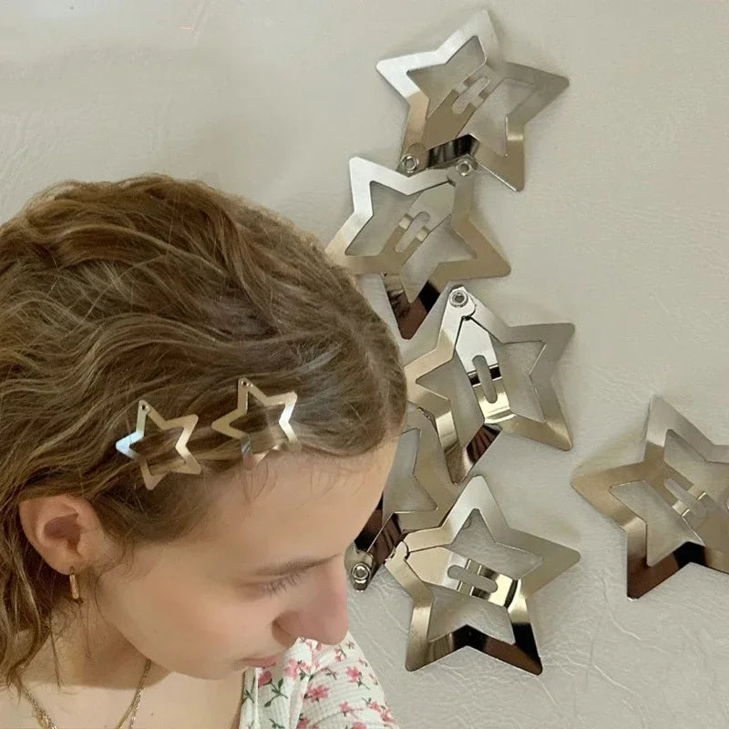 Silver star snap hair clips on a light-brown ponytail, metal filigree star design.