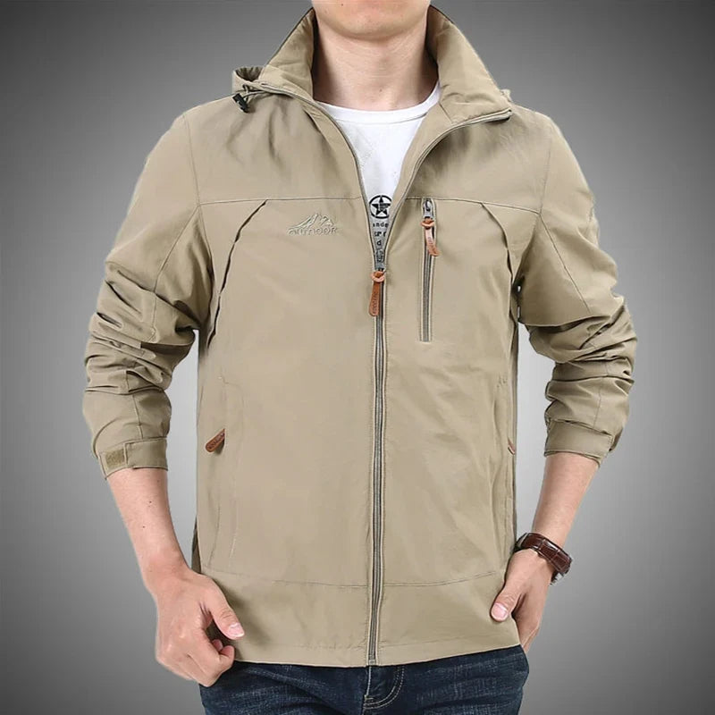 Beige hooded waterproof windbreaker jacket on model, full zipper front and side pockets.