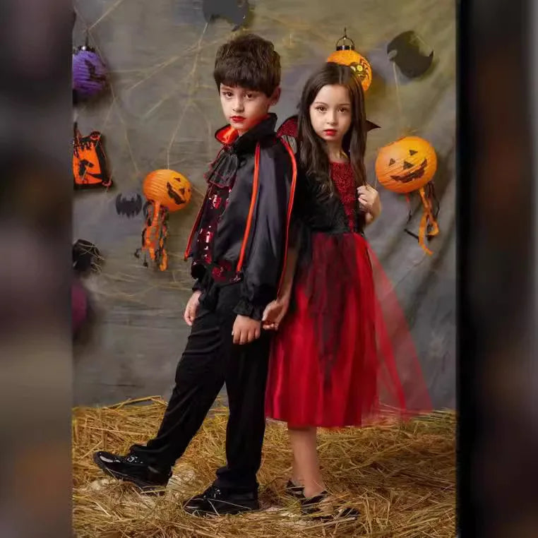 Kids vampire Halloween costumes: boy in black/red outfit and girl in red tulle dress