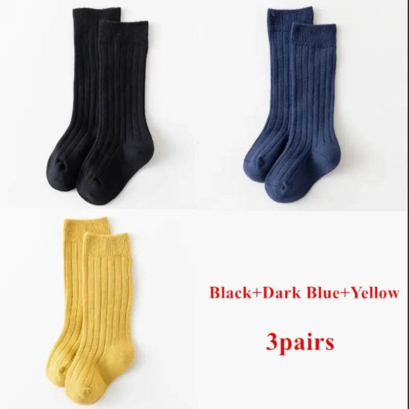 Kids knee-high striped socks in black, dark blue, and yellow, shown as three pairs.