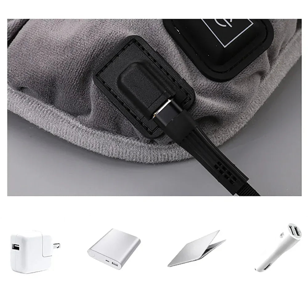 Gray heating pad cushion detail with attached power cable and control unit on fabric.