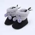 Baby gray and black booties with plush cuffs, bow laces, and pompom accents