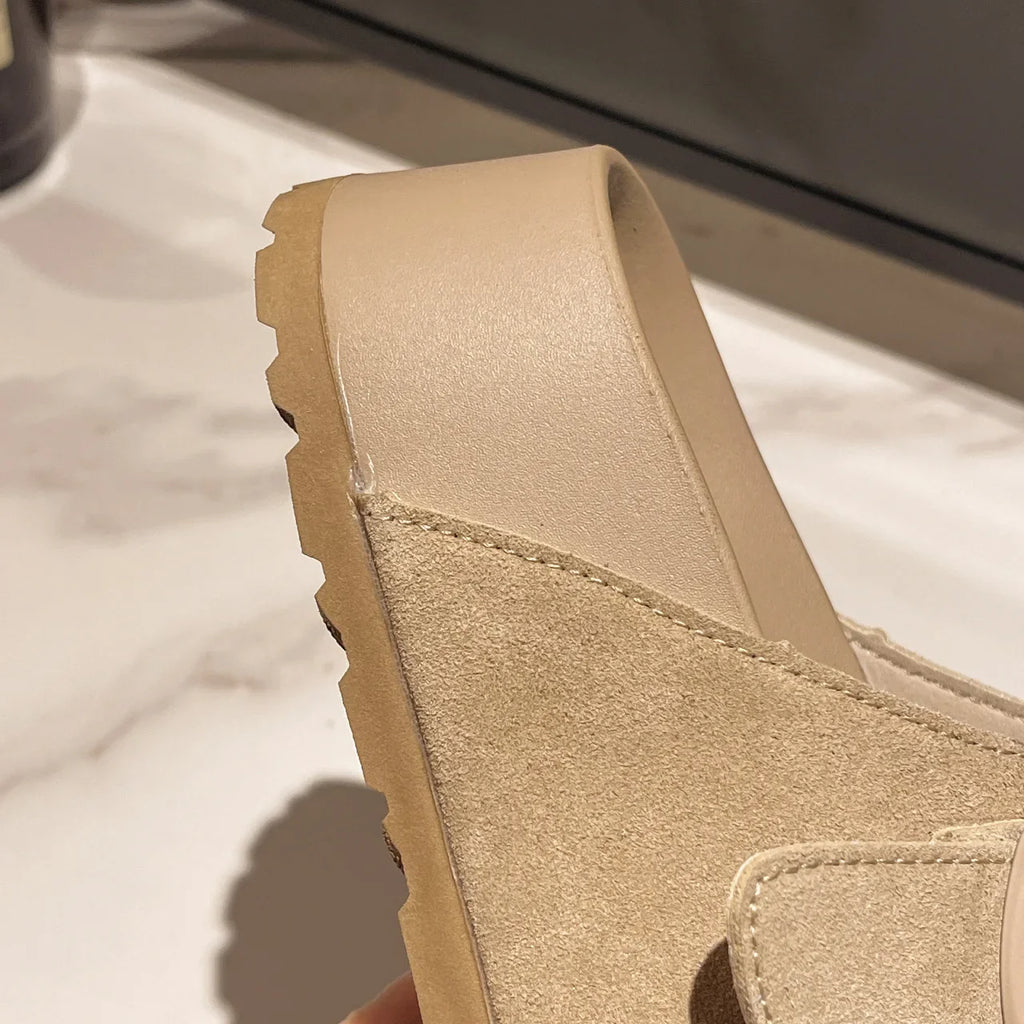 Beige suede-look platform slide sandal side view with textured strap detail.