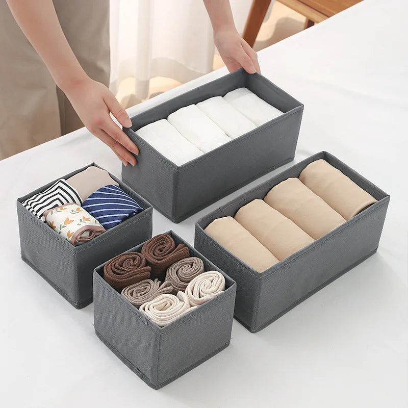 Gray foldable fabric organizer cube bins with lids, holding folded underwear and socks