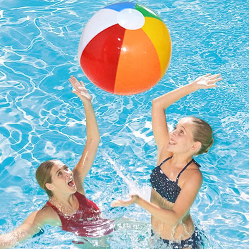 Colorful inflatable beach ball floating on pool water near children