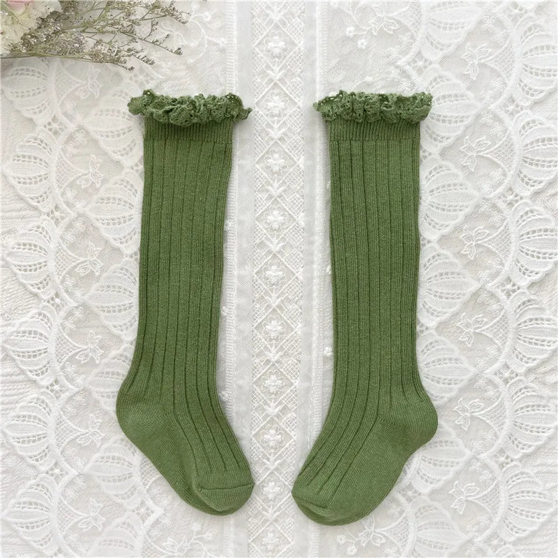 Knee-high ruffle socks with lace cuff, green pair laid flat