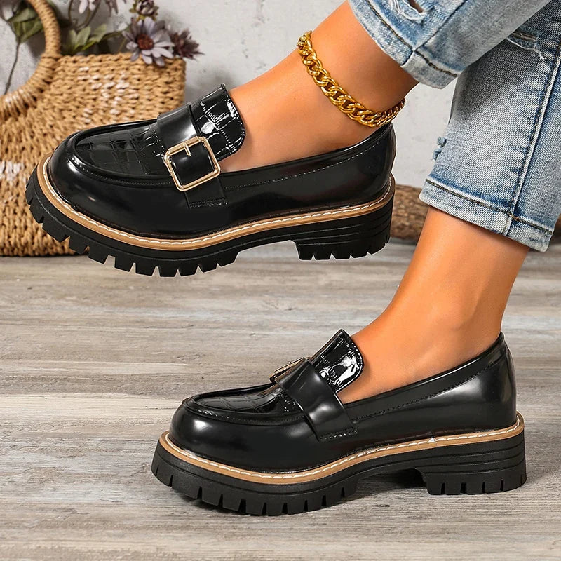 Black patent leather loafers with buckle strap, chunky sole, side view
