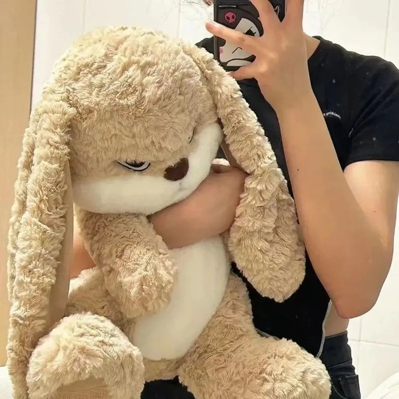 Angry long-eared rabbit plush held in arms, sleepy closed eyes and soft fur