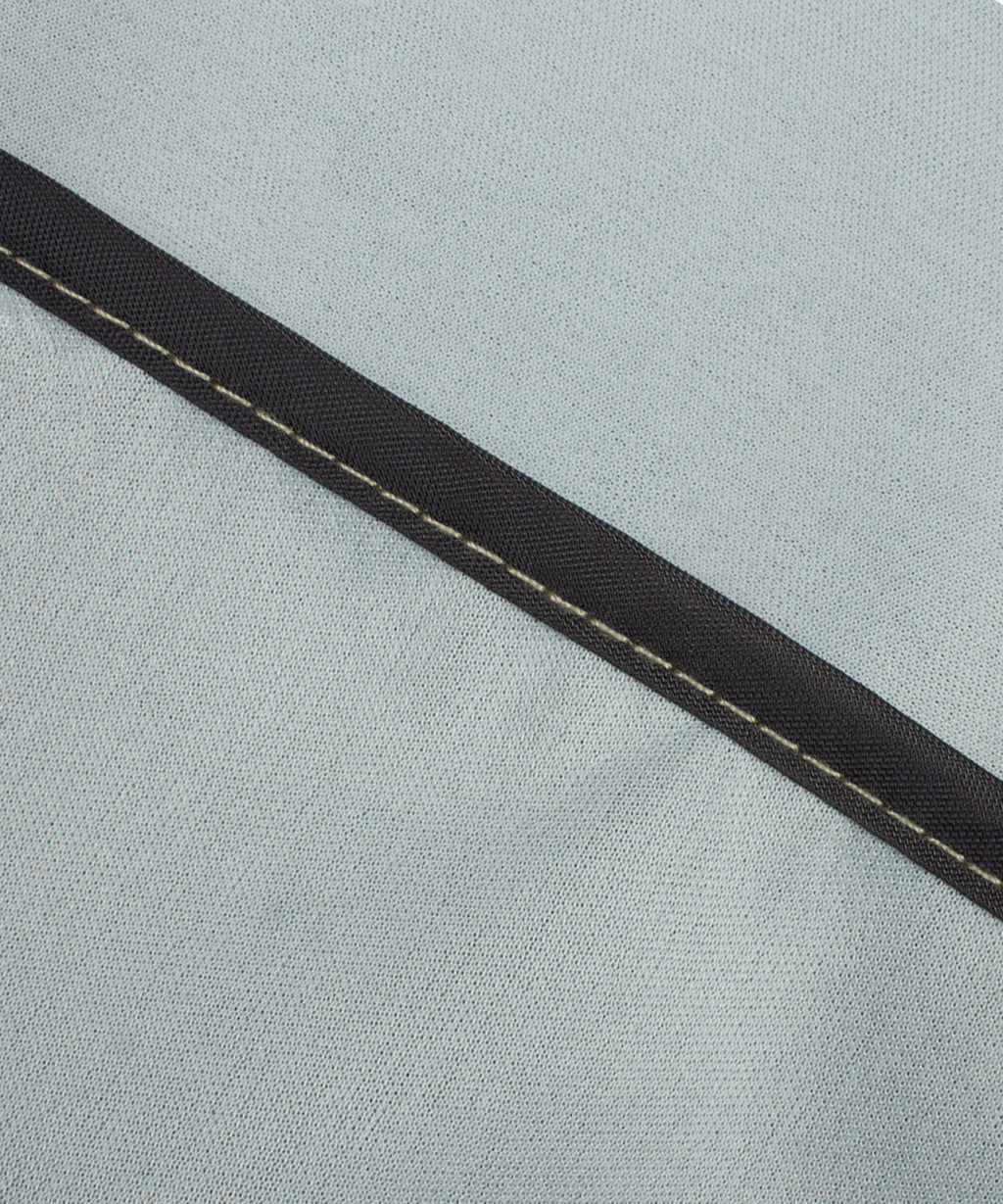 Textured gray cover fabric with dark trim seam along the edge