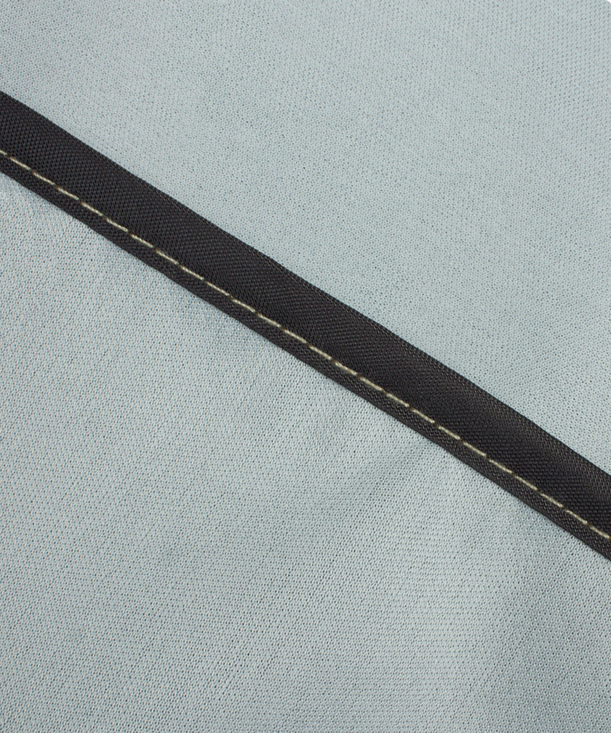 Textured gray cover fabric with dark trim seam along the edge
