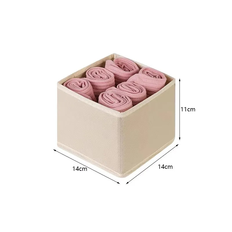 Beige folding drawer organizer box with four rolled items, open-top storage