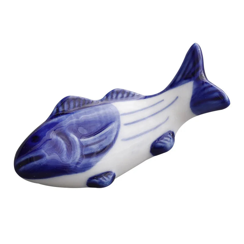 Close-up ceramic fish chopstick holder with blue glazed body and white details