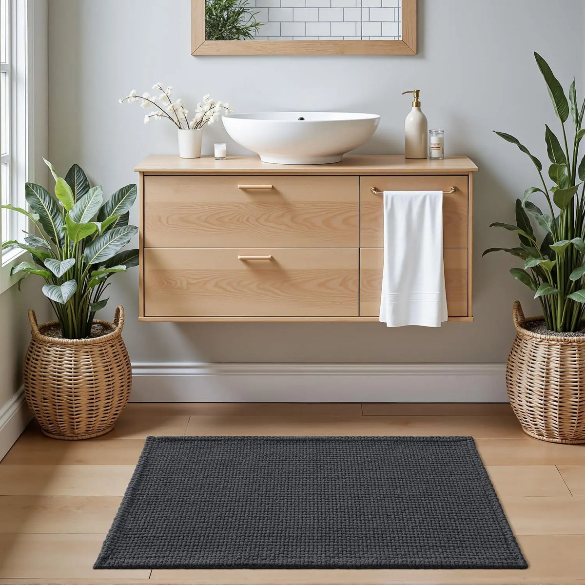Dark grey bath rug with thick textured weave, placed on bathroom floor