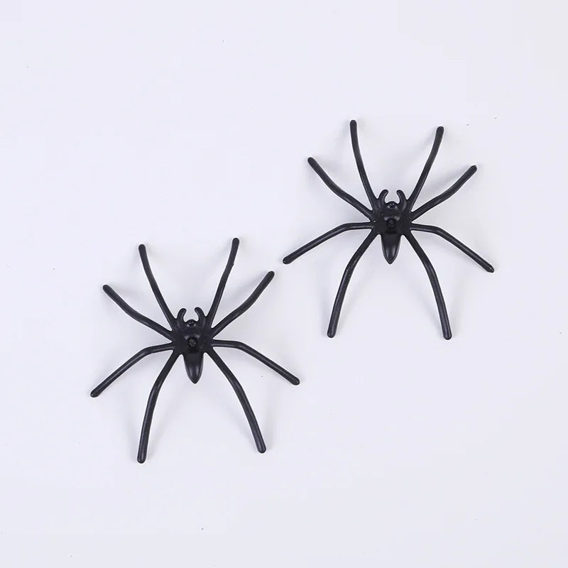 Pair of black spider prank toys with round bodies and multiple bent legs