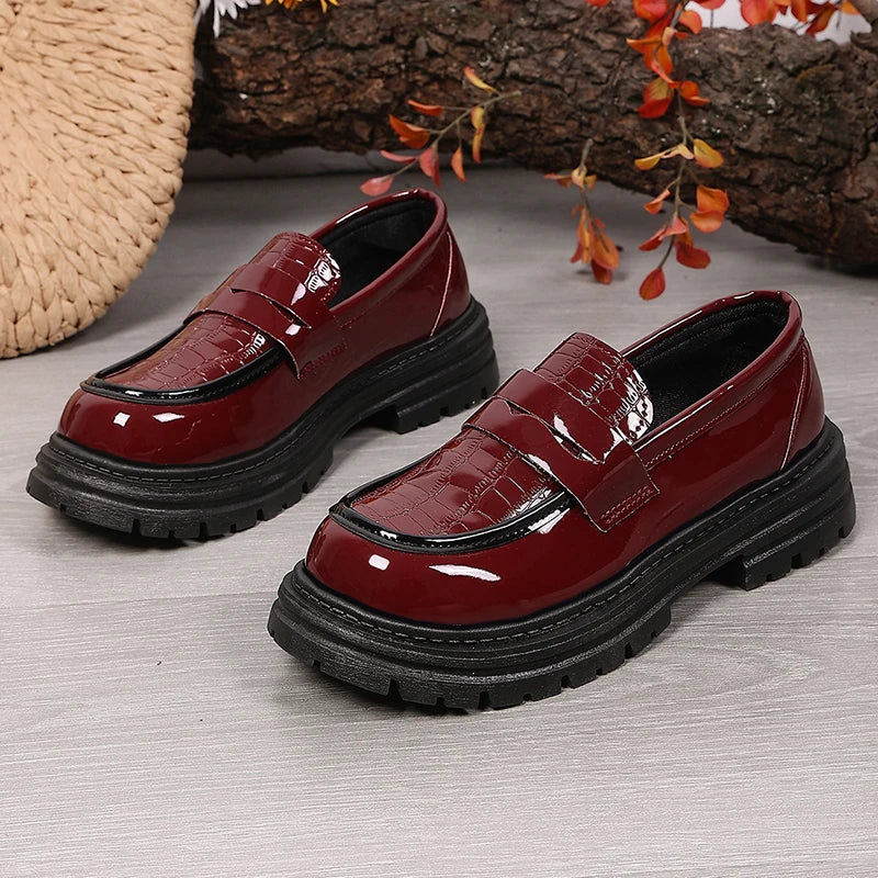Pair of red patent platform loafers with chunky sole and buckle strap detail