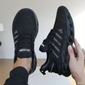 Black knit lace-up sports shoes with thick tread sole and textured breathable upper