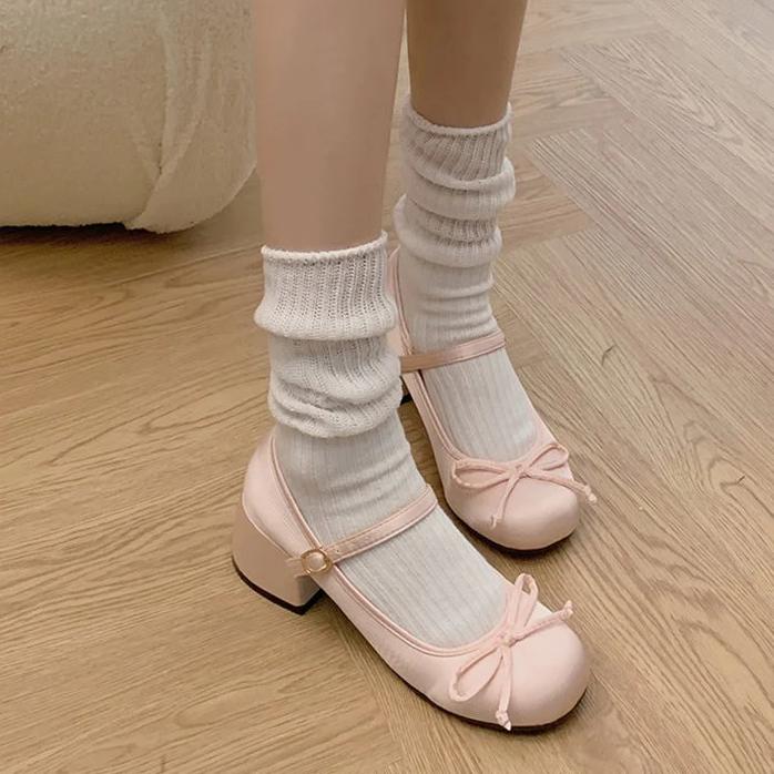 Pink Mary Jane ballet flats with ankle strap and bow, worn with white ribbed socks
