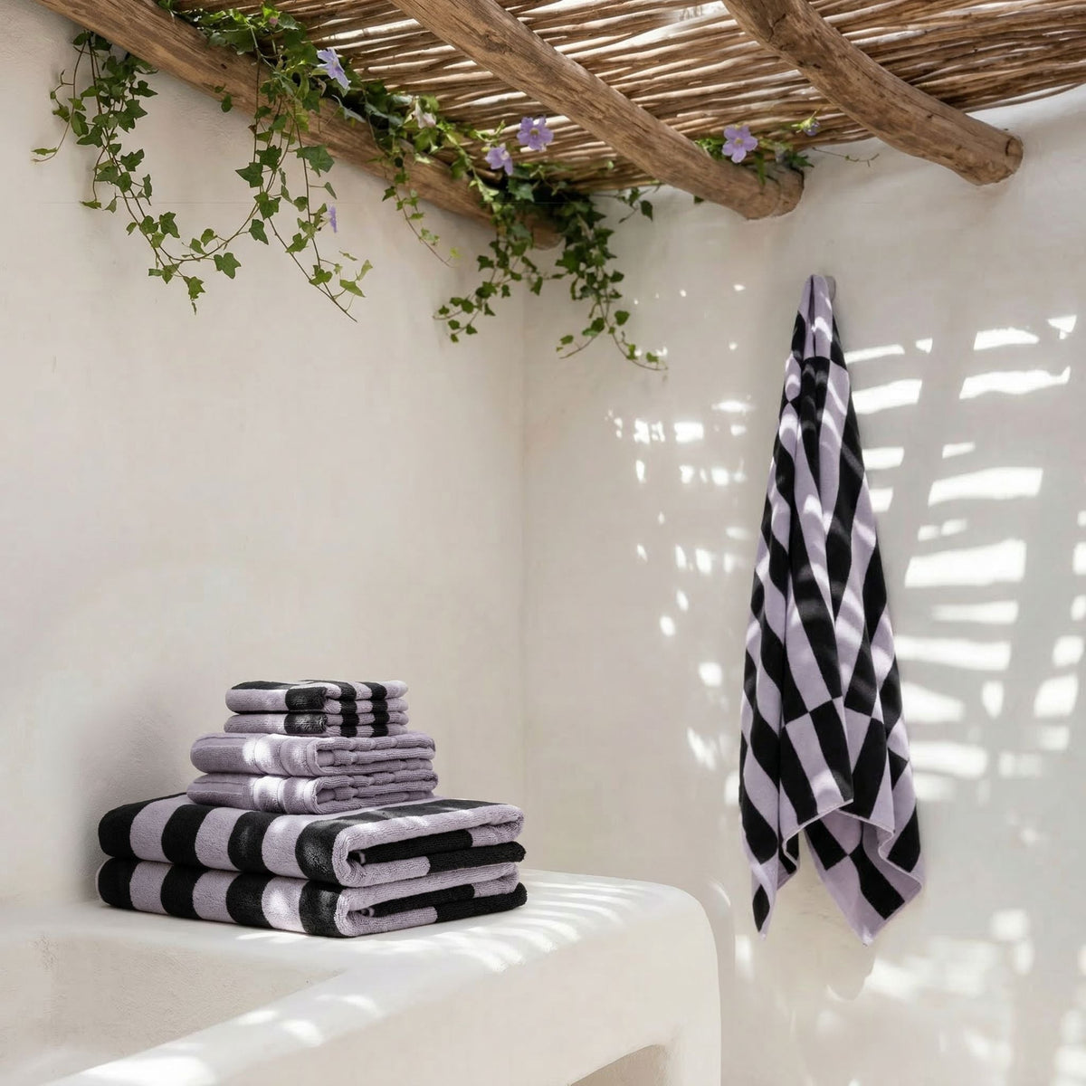 Black and white striped towels stacked with one towel hanging in a lounge corner