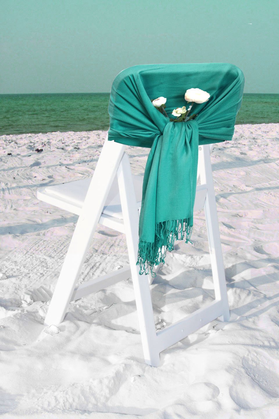 Solid teal pashmina-style shawl wrap scarf with fringed hem, draped on chair