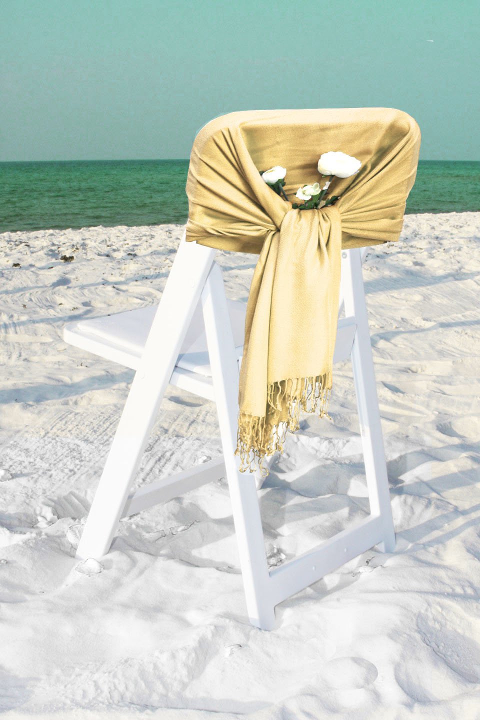Beige pashmina-style shawl wrap scarf with fringe ends, neatly draped over chair.