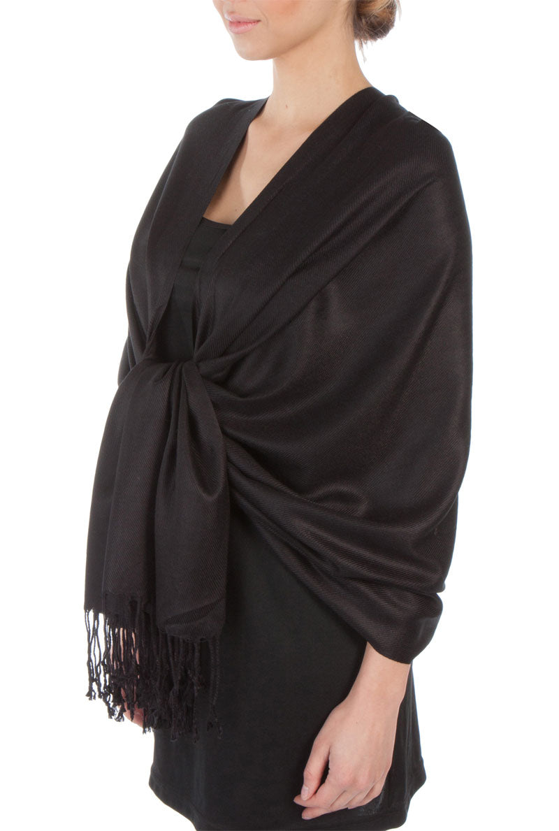 Pashmina-feel shawl wrap scarf in dark black, draped over shoulder, fringed hem