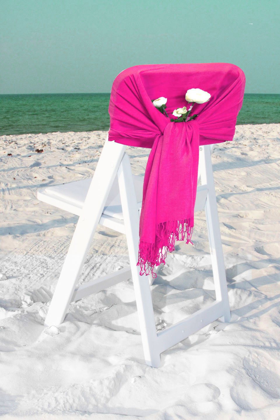 Bright magenta pashmina-style shawl wrap scarf draped over a chair with fringe