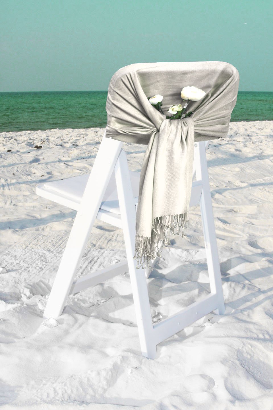 Solid light gray pashmina-style shawl wrap scarf with fringe hem, draped over chair