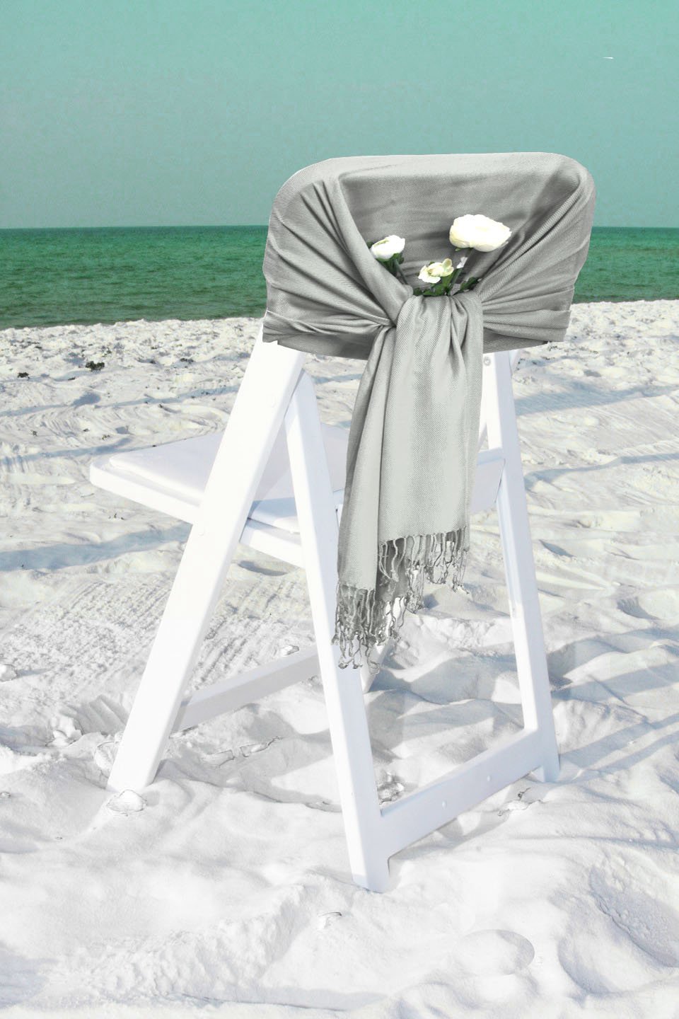 Solid light gray pashmina-style shawl wrap scarf with fringe hem, draped on chair